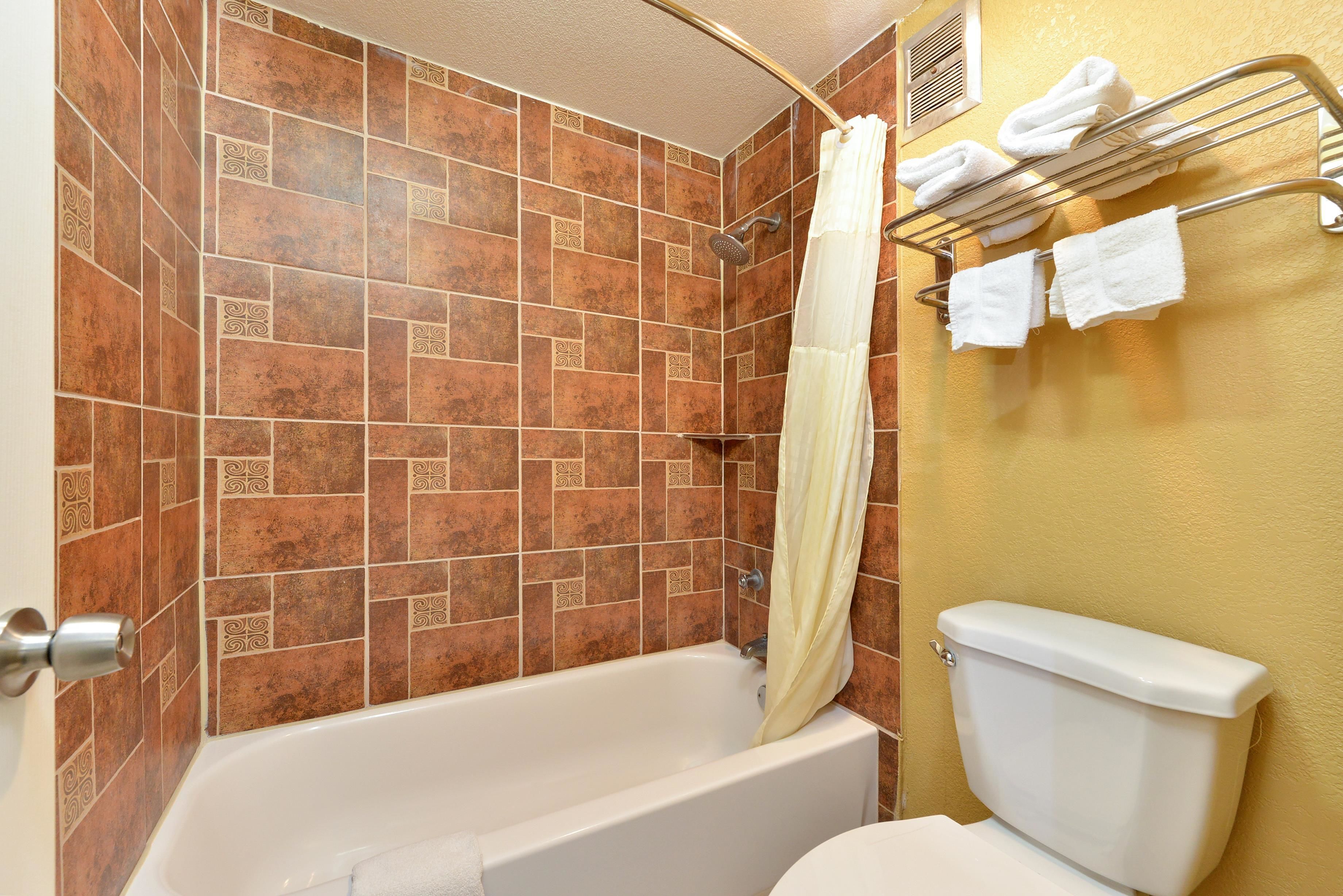 Un baño con bañera, ducha e inodoro.