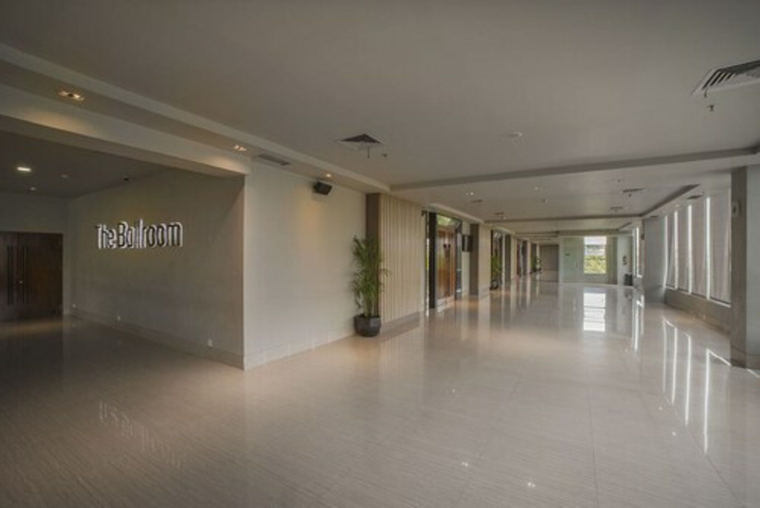 Ein geräumiger, moderner Hotelkorridor, auf der linken Seite ein Schild mit der Aufschrift "The Ballroom".