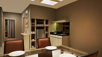 Une chambre d’hôtel moderne dotée d’un coin repas, d’une kitchenette et d’une salle de bain.