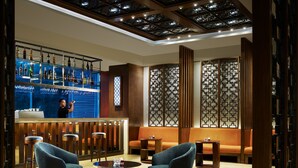 A bar area with stools, a sofa, and a decorative screen.