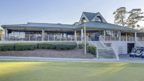 A building with a covered patio, a staircase, and a golf cart parking area. - Ocean Cove At Palmetto Dunes (Hilton Head Island)