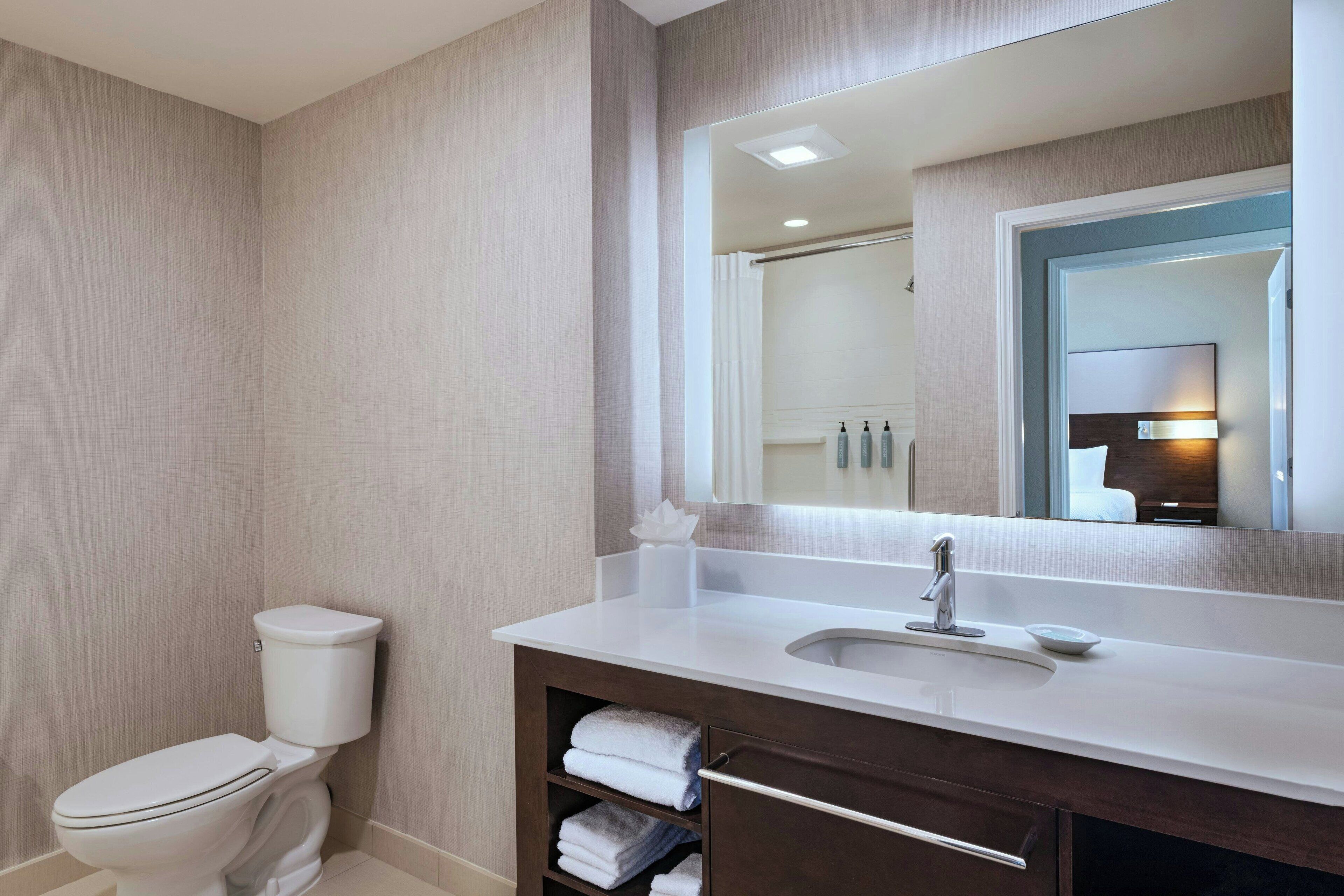 Une salle de bain moderne avec des toilettes, un lavabo et un miroir.