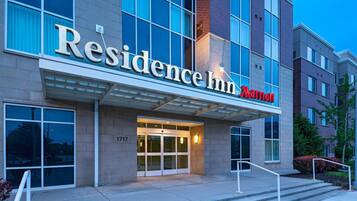 A modern building with a large entrance, a sign reading "Residence Inn Marriott," and a number "1717" on the wall.