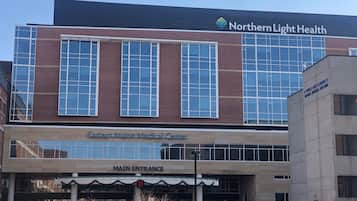A modern medical center with a prominent Northern Light Health sign, a main entrance, and a visible G. Pence and Florence P. Weber Medical Building.