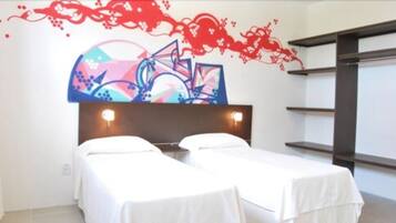 Habitación de hotel con dos camas individuales, un mural abstracto grande en la pared y un cabecero moderno.