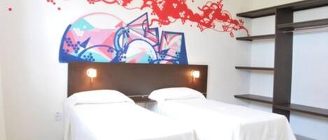 A hotel room with two single beds, a large abstract mural on the wall, and a modern headboard.
