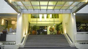 A modern building entrance with a glass facade, a staircase leading up to the entrance, and potted plants on either side. - The Jerai Hotel Alor Star (Alor Setar)