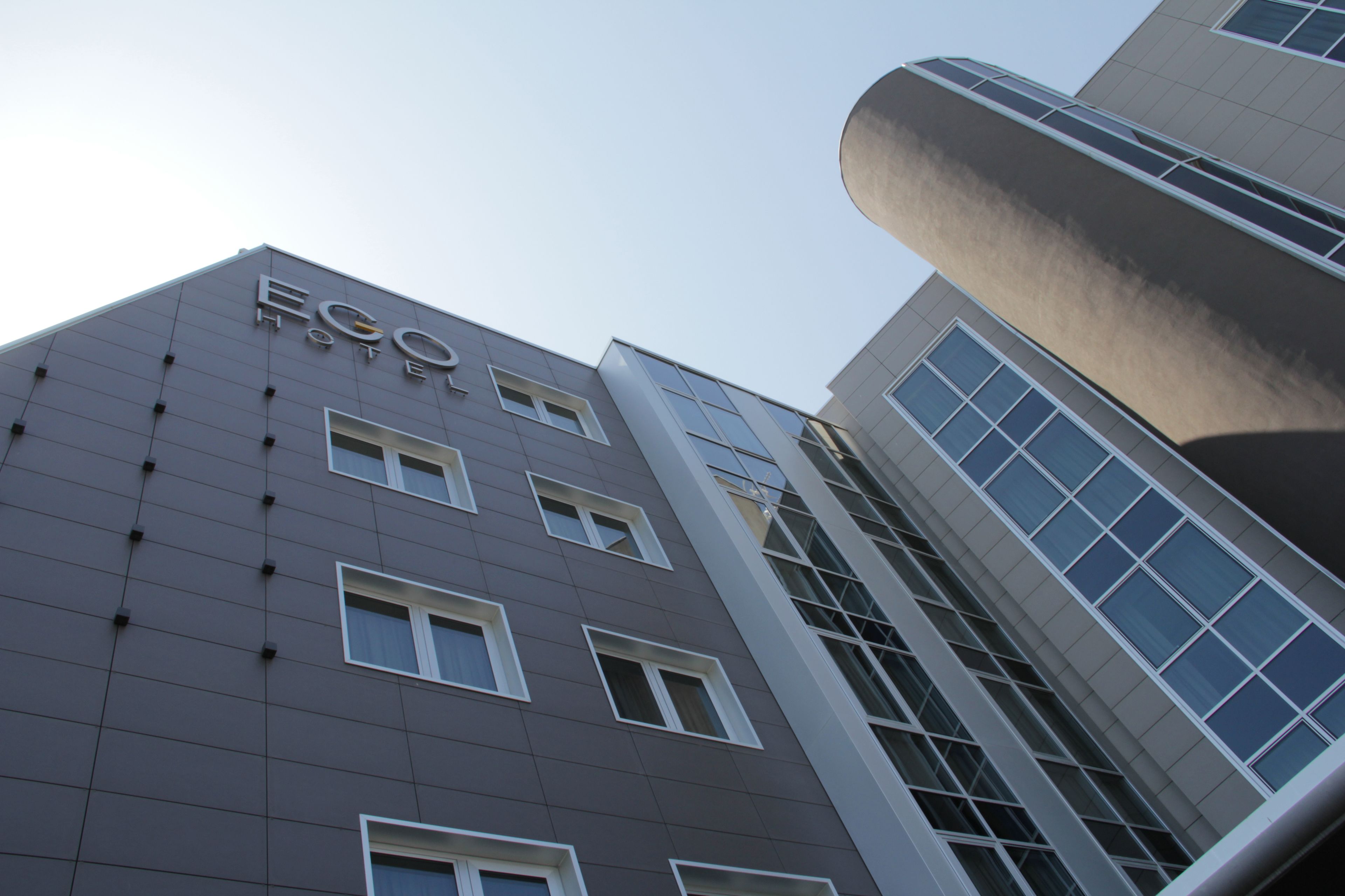 A modern hotel building with a prominent 'Eco Hotel' sign.