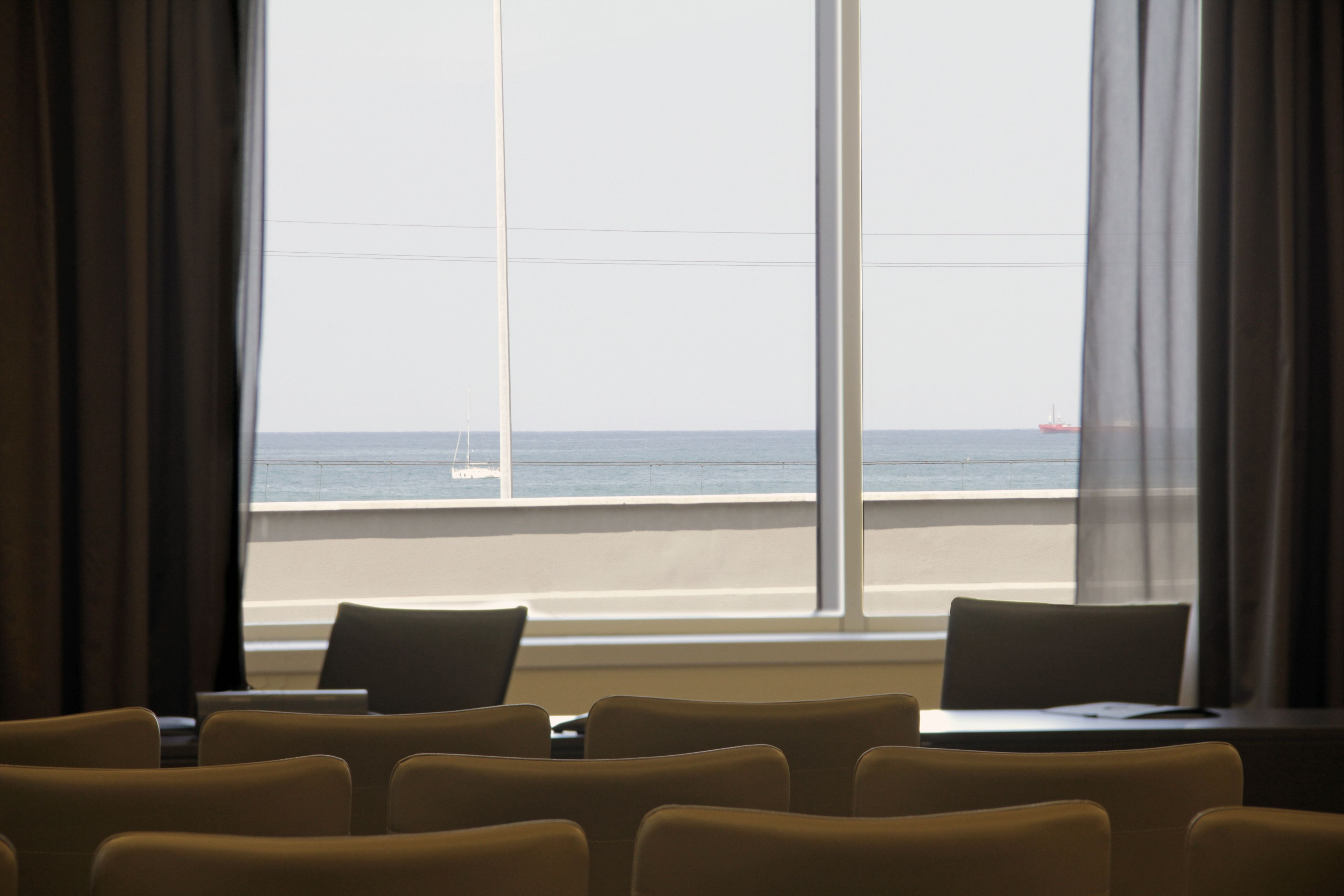 Una habitación de hotel con vista al mar, una mesa y varias sillas.