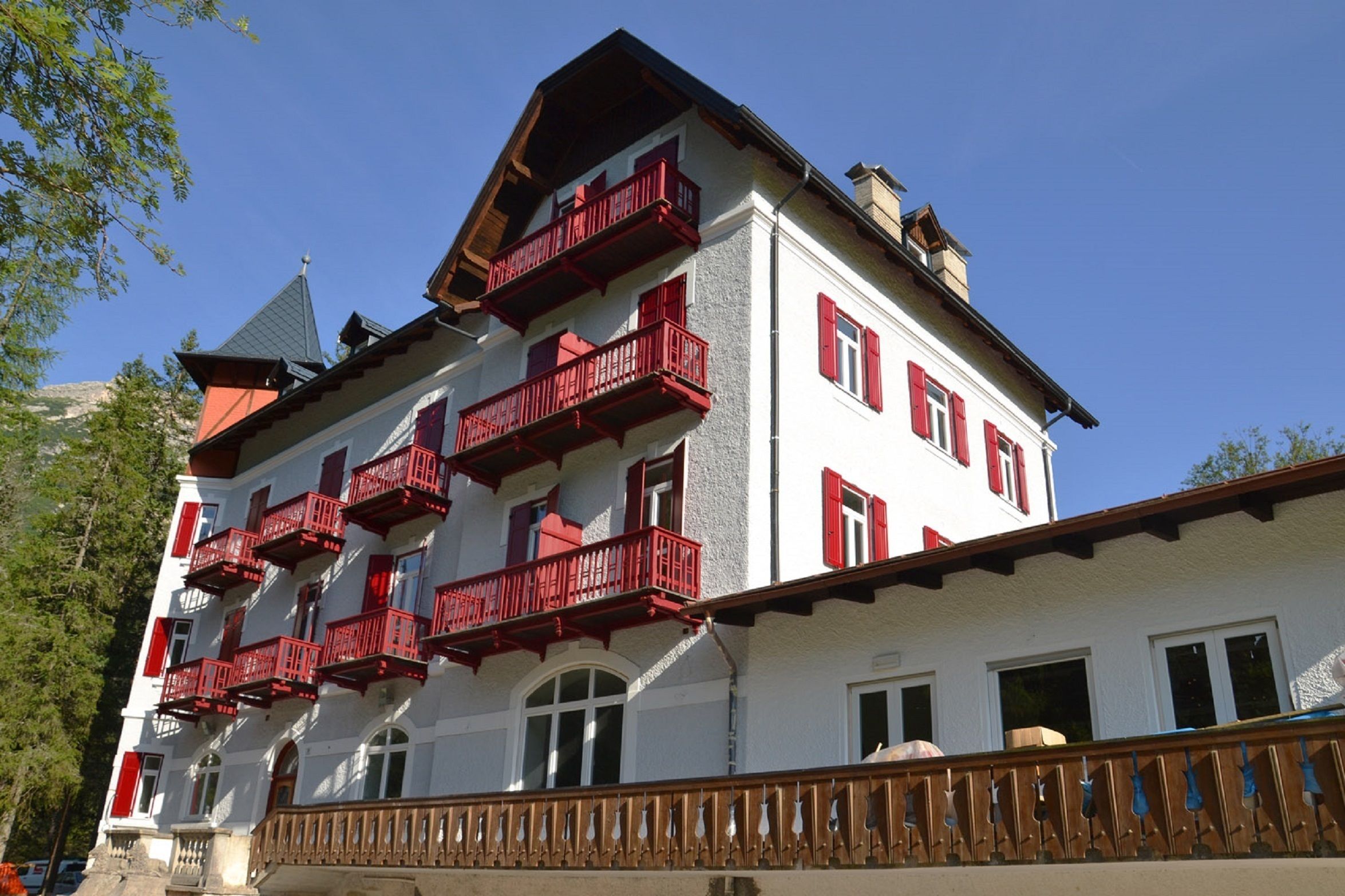A multi-story building with red balconies and white walls.