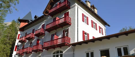 A multi-story building with red balconies and white walls.