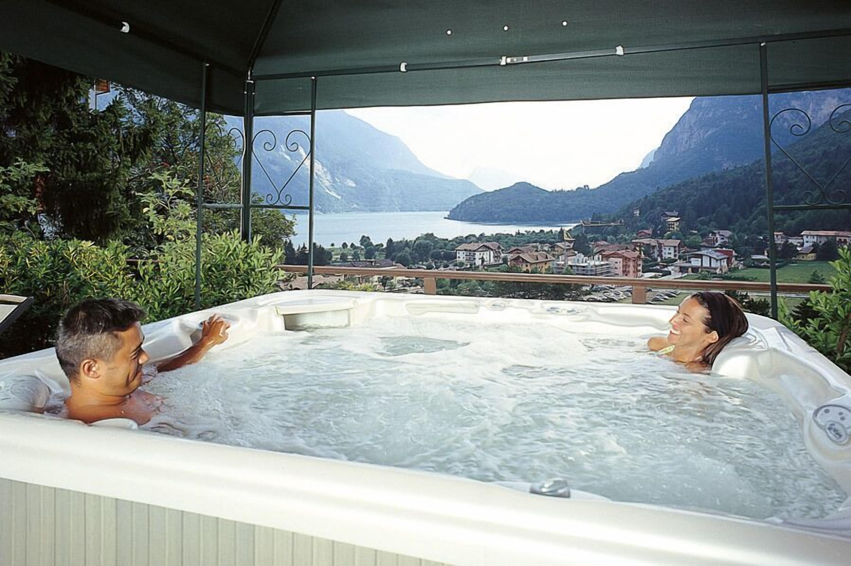 A hot tub with a view of a lake and mountains.