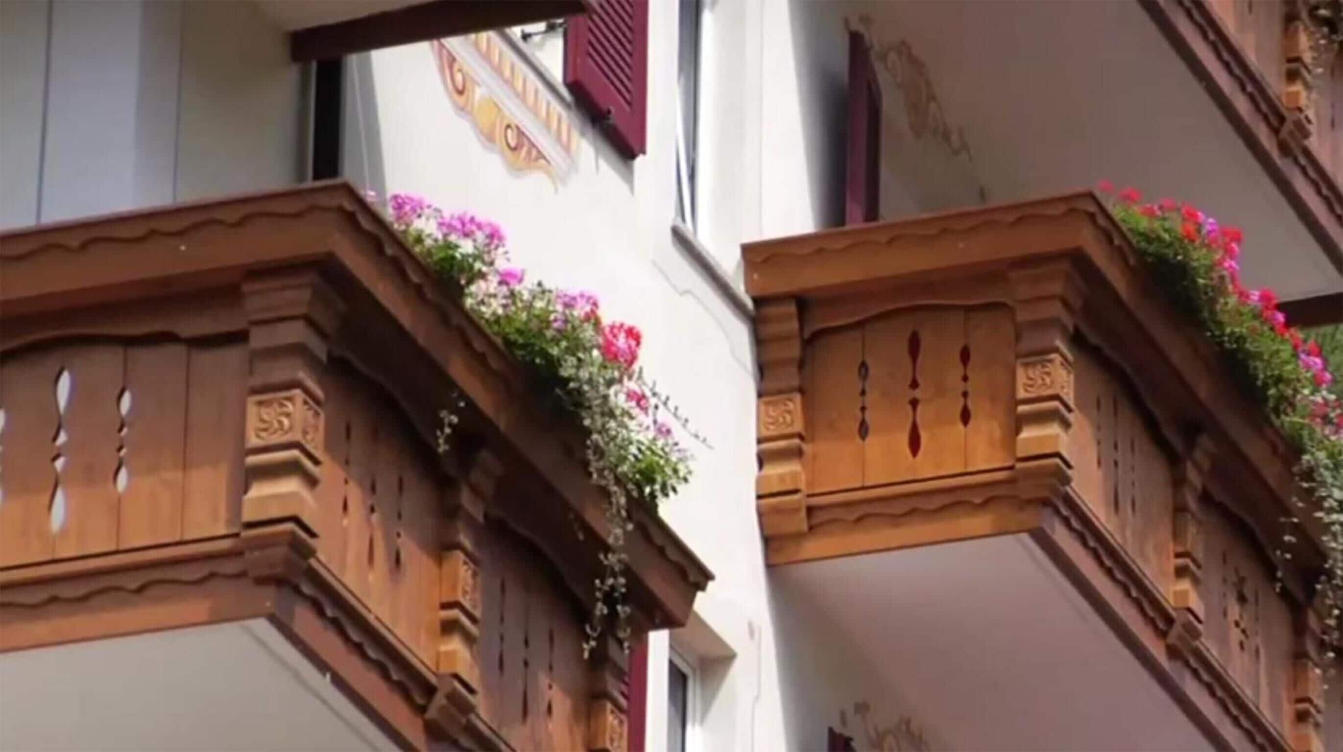 A building with wooden balconies adorned with flowers.