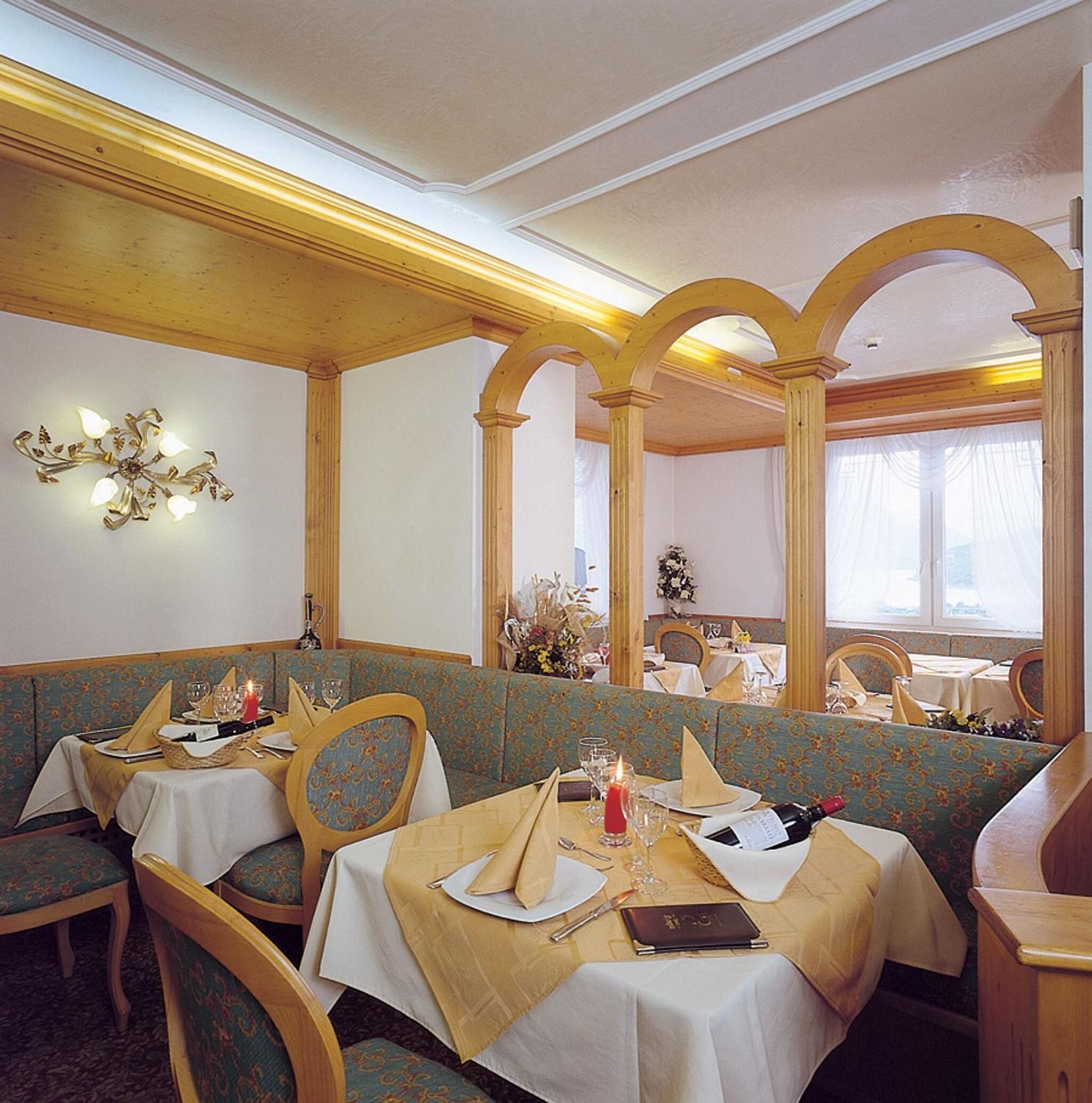 Ein Restaurant mit Holzkabinen, weißen Tischdecken und einem Kronleuchter.