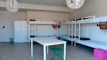 Een kamer met stapelbedden, een tafel en een stoel.