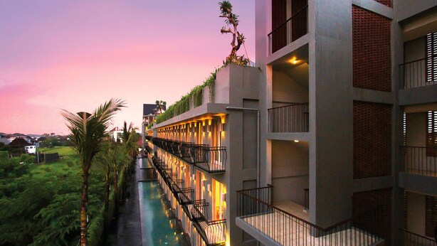 A hotel with a pool, balconies, and a view of the surrounding greenery. - FRii Bali Echo Beach (Canggu)