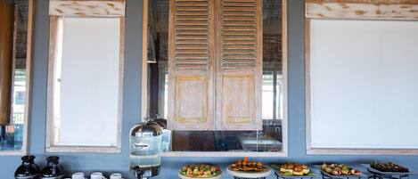 Un buffet de petit-déjeuner proposant divers plats, un coin café et un distributeur d’eau.
