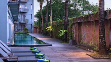 A poolside area with lounge chairs and a pool.