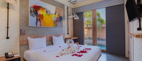 A hotel room with a large bed, a painting on the wall, a telephone on the nightstand, and a television mounted on the wall.