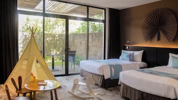 Habitación de hotel con dos camas, una mecedora, una mesita y un tipi.