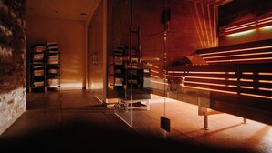 A modern interior with a wooden bench, glass partitions, and shelves with folded items. - Hotel & Restaurant Goldener Pflug (Ludwigsburg)