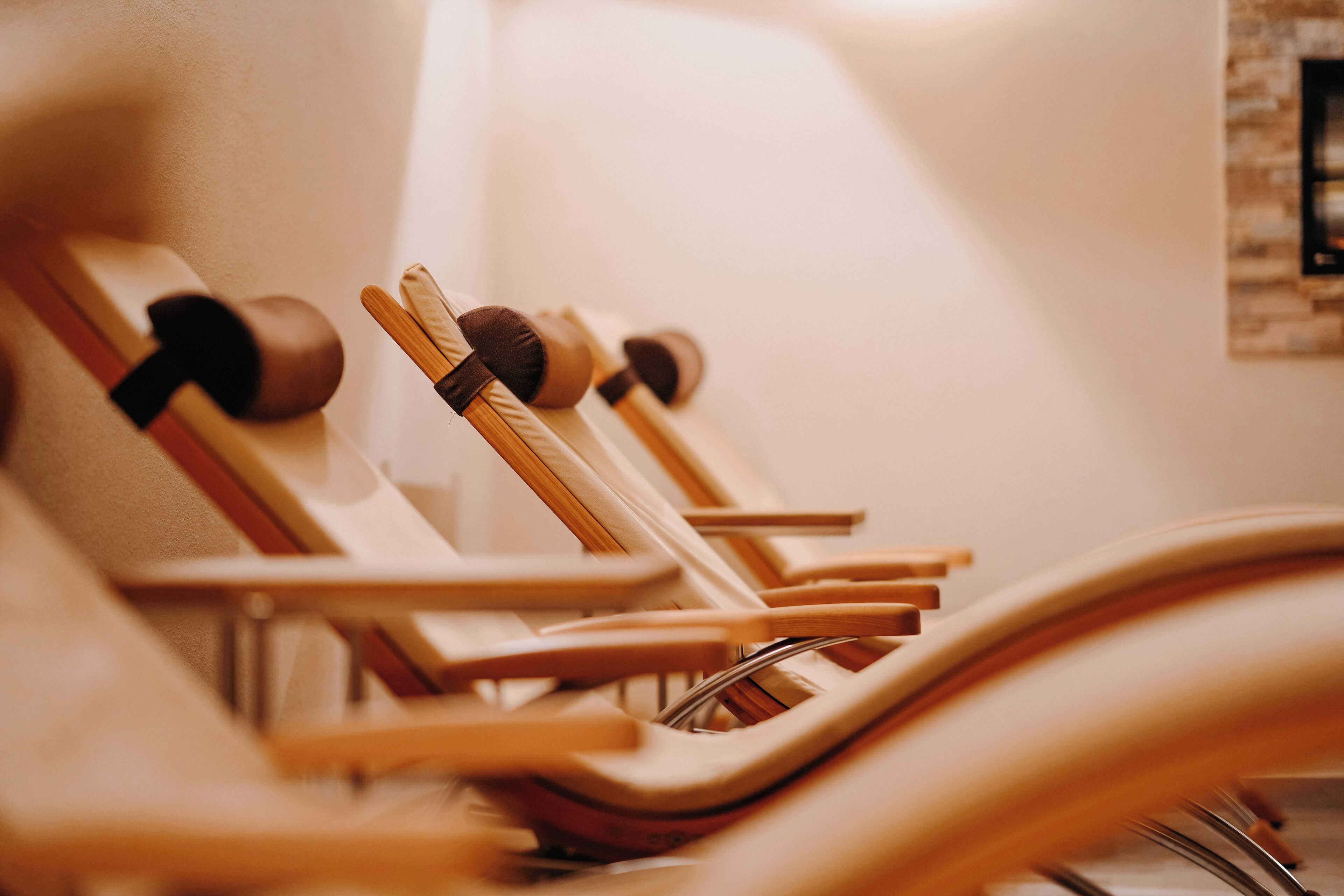 A row of wooden chairs with metal frames, arranged in a row, likely in a waiting area or lounge.
