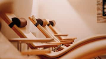 A row of wooden chairs with metal frames, arranged in a row, likely in a waiting area or lounge.