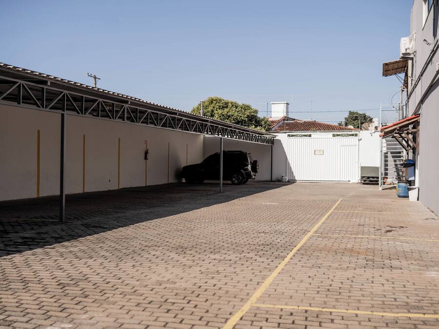 Un estacionamiento con superficie pavimentada y un vehículo dentro.