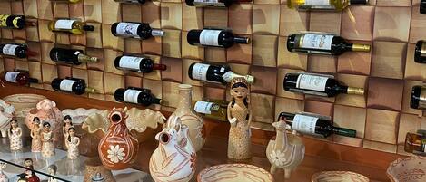 A wine rack with various bottles and ceramic dinnerware on display.
