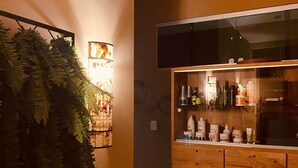 A modern kitchen with a wooden cabinet, a hanging light fixture, and a fern decoration. - Serra Negra Pousada Spa by Easy Hoteis (Guarapari)