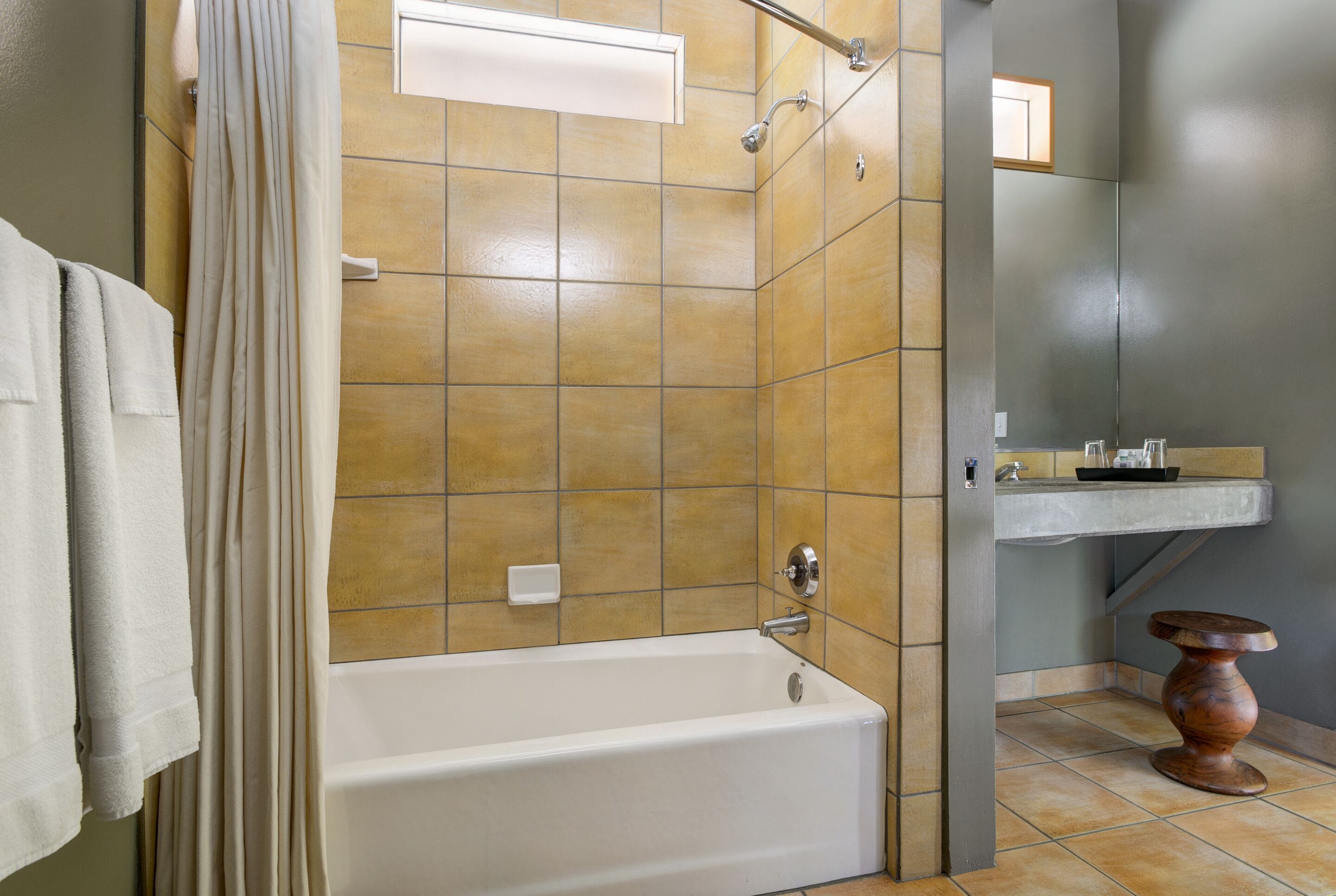 A bathroom with a bathtub, a shower, and a vanity with a sink.