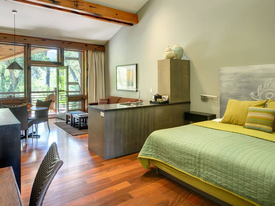 Een moderne hotelkamer met een groot bed, een bureau en een zithoek.