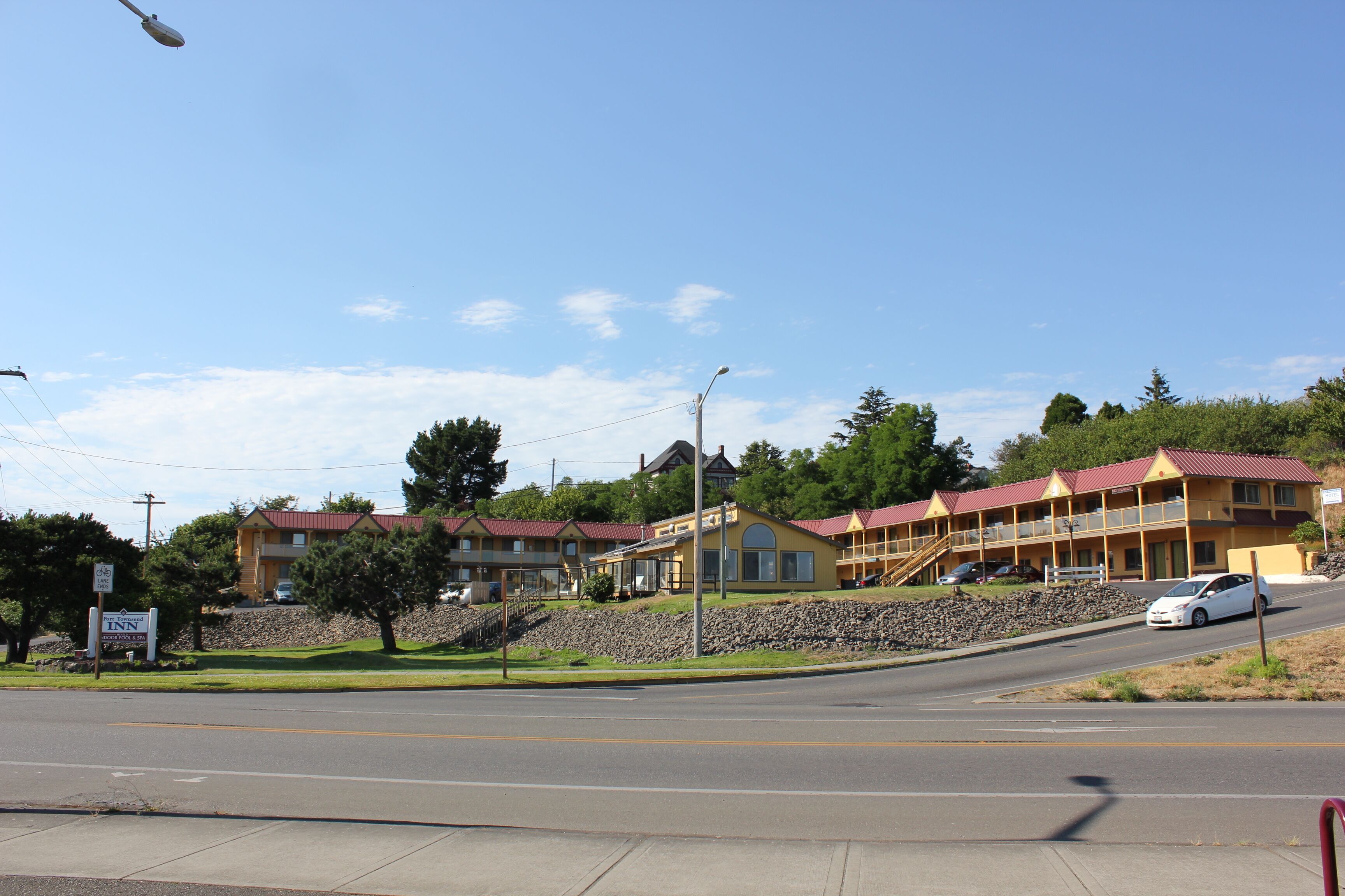 Um motel com vários edifícios, um muro de pedra e céu claro.