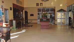 A spacious lobby with a reception desk, a wooden bench, a glass door entrance, and a decorative plant centerpiece. - Hotel Seri Malaysia Kuantan (Kuantan)
