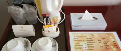 A tray with a coffee pot, cups, and a menu.