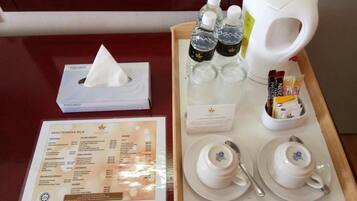 Un plat amb teiera, tasses i condiments, juntament amb un menú i una caixa de mocadors.