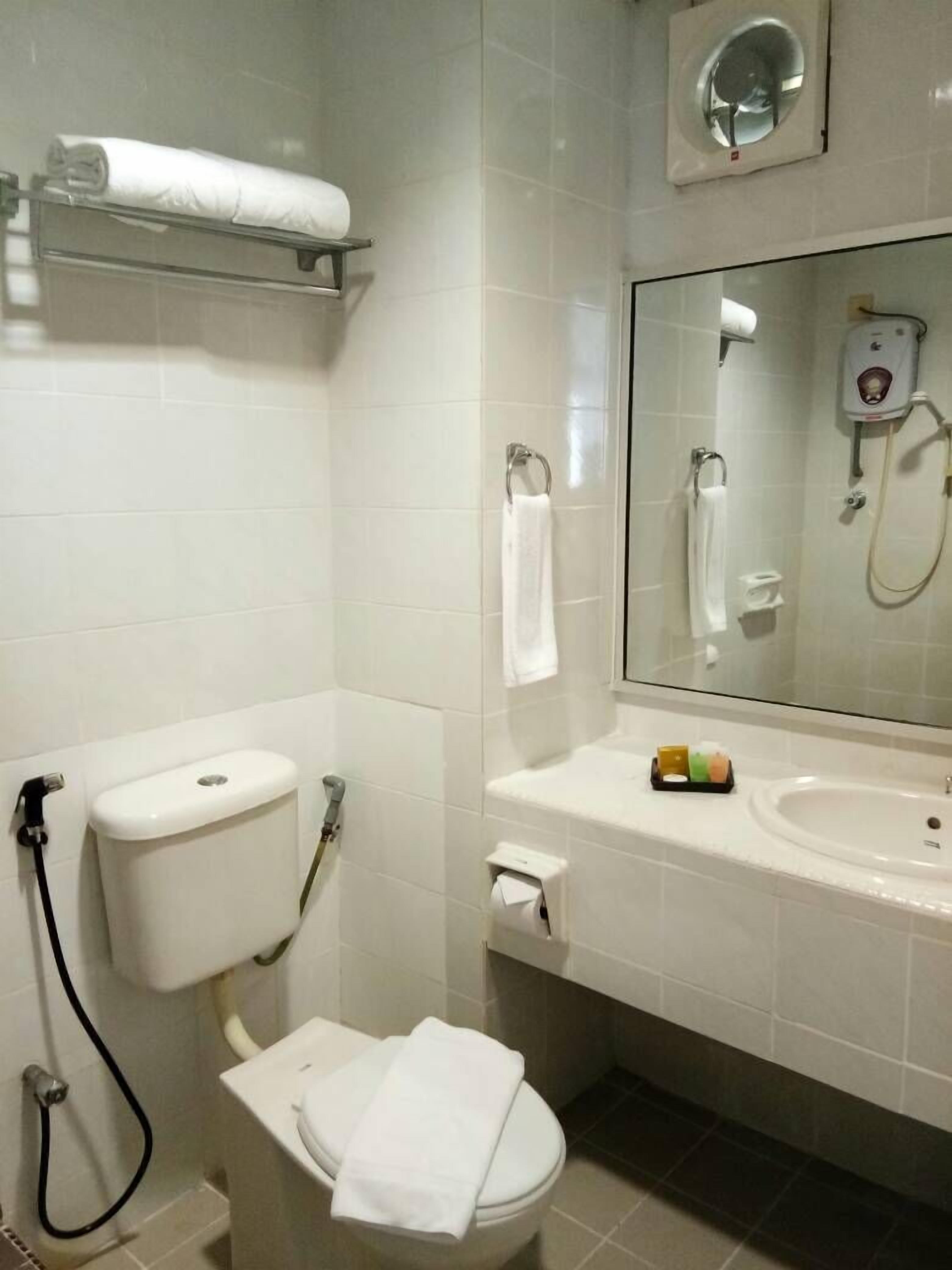 A modern bathroom with a toilet, sink, and a mirror.