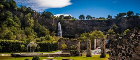 Un sitio histórico con ruinas, una cascada y un jardín bien cuidado.