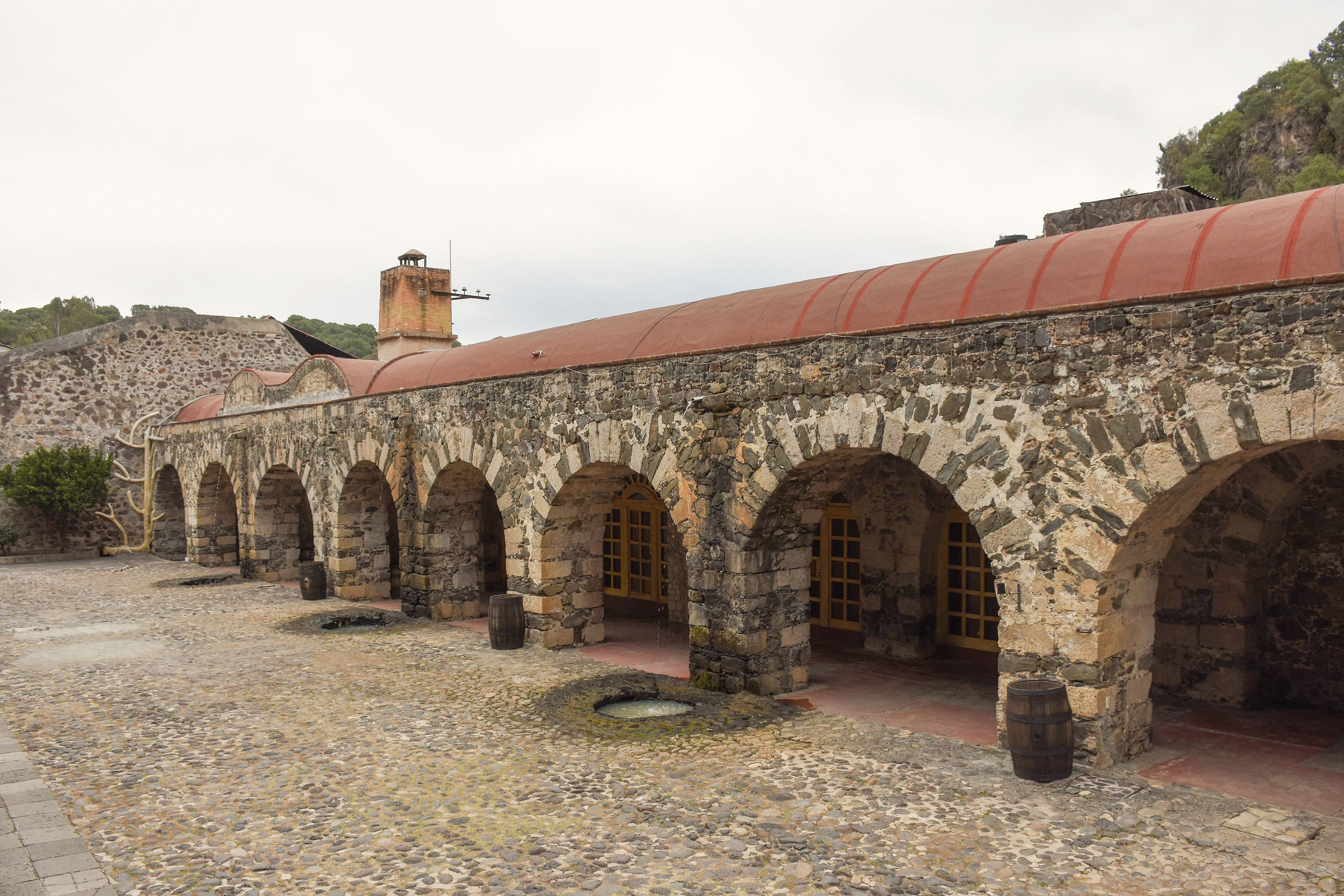 Un edificio histórico con arcos de piedra y techo rojo.