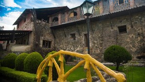 A historic stone building with a rustic facade, a covered entrance, and a well-maintained garden with trimmed bushes and a small tree. - Hacienda Santa Maria Regla (San Miguel Regla)