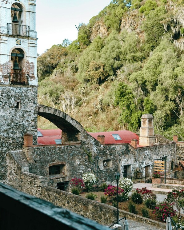 A stone bridge, a bell tower, and a building with a red roof. - Hacienda Santa Maria Regla (San Miguel Regla)