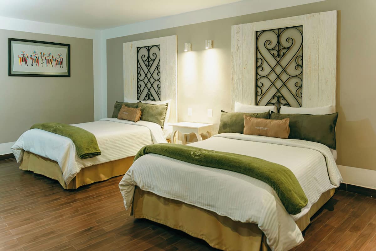 A hotel room with two beds, a small table, and decorative wall panels.