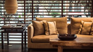 A modern living room with a sofa, a wooden coffee table, and a hanging light fixture. - 27 Suites Apart Hotel (Montevideo)