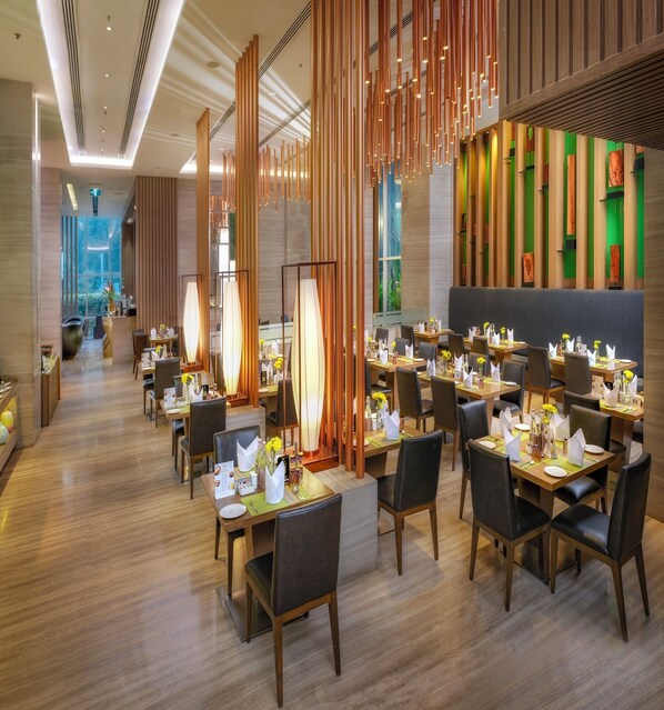 A modern restaurant with wooden floors, high tables, and chairs. - Welcomhotel by ITC Hotels, Richmond Road, Bengaluru (Bengaluru)