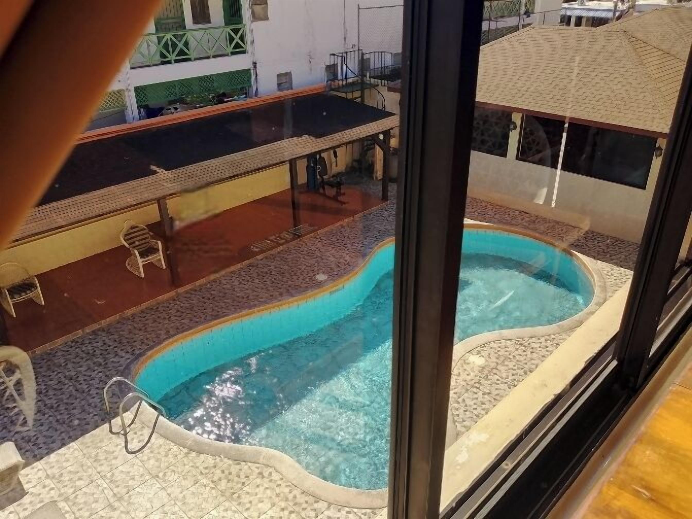A rooftop swimming pool with a view of a building in the background.