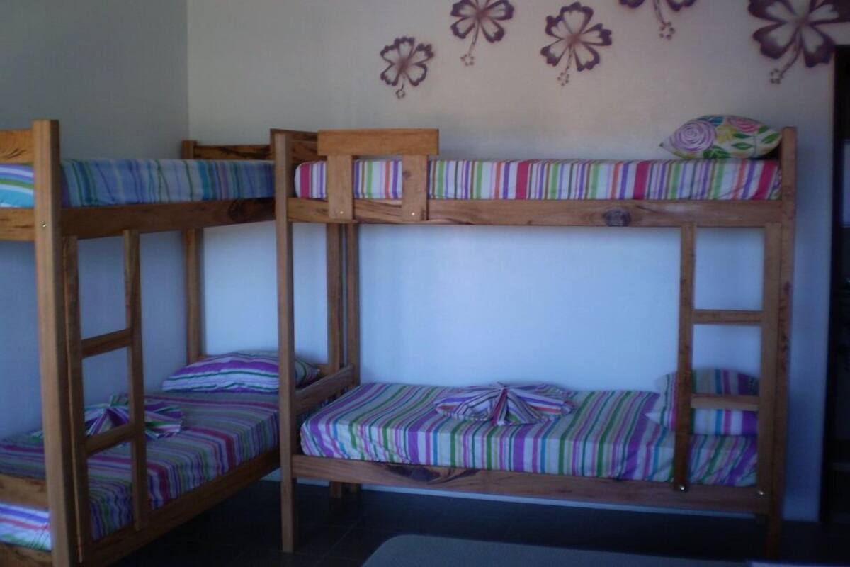 Ein Stockbett mit gestreifter Bettwäsche und eine Wand mit floralen Verzierungen.