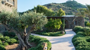 A stone building with a pathway leading to a hilltop structure. - Resort Acropoli (Pantelleria)