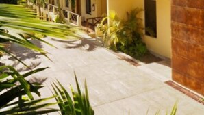 A two-story building with balconies, surrounded by greenery and palm trees. - Hotel Maya Balam (Calakmul)