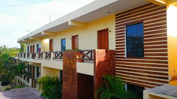 A multi-story building with a flat roof, balconies, and a wooden facade. - Hotel Maya Balam (Calakmul)