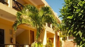 A two-story building with a covered outdoor area, a staircase, and lush greenery. - Hotel Maya Balam (Calakmul)
